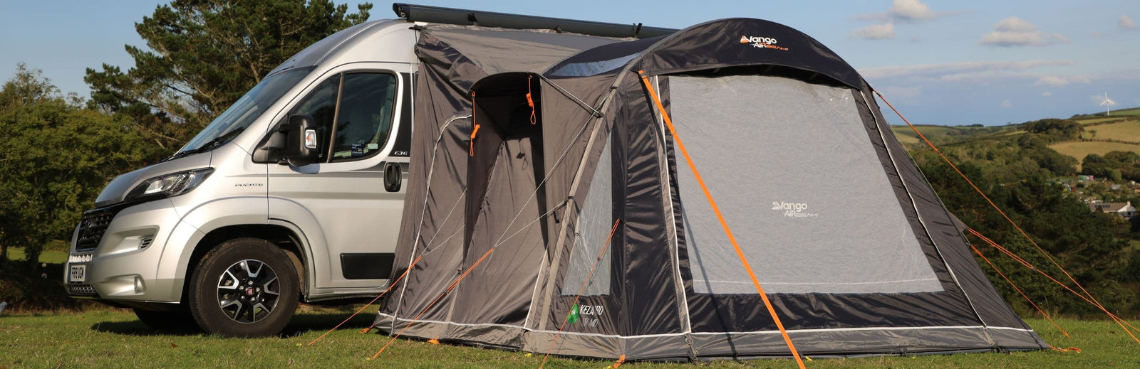 Vango Kela Pro Air Mid Drive Away Awning attached to a campervan, showcasing the inflatable AirBeam structure and mid-height design, ideal for versatile camping setups.