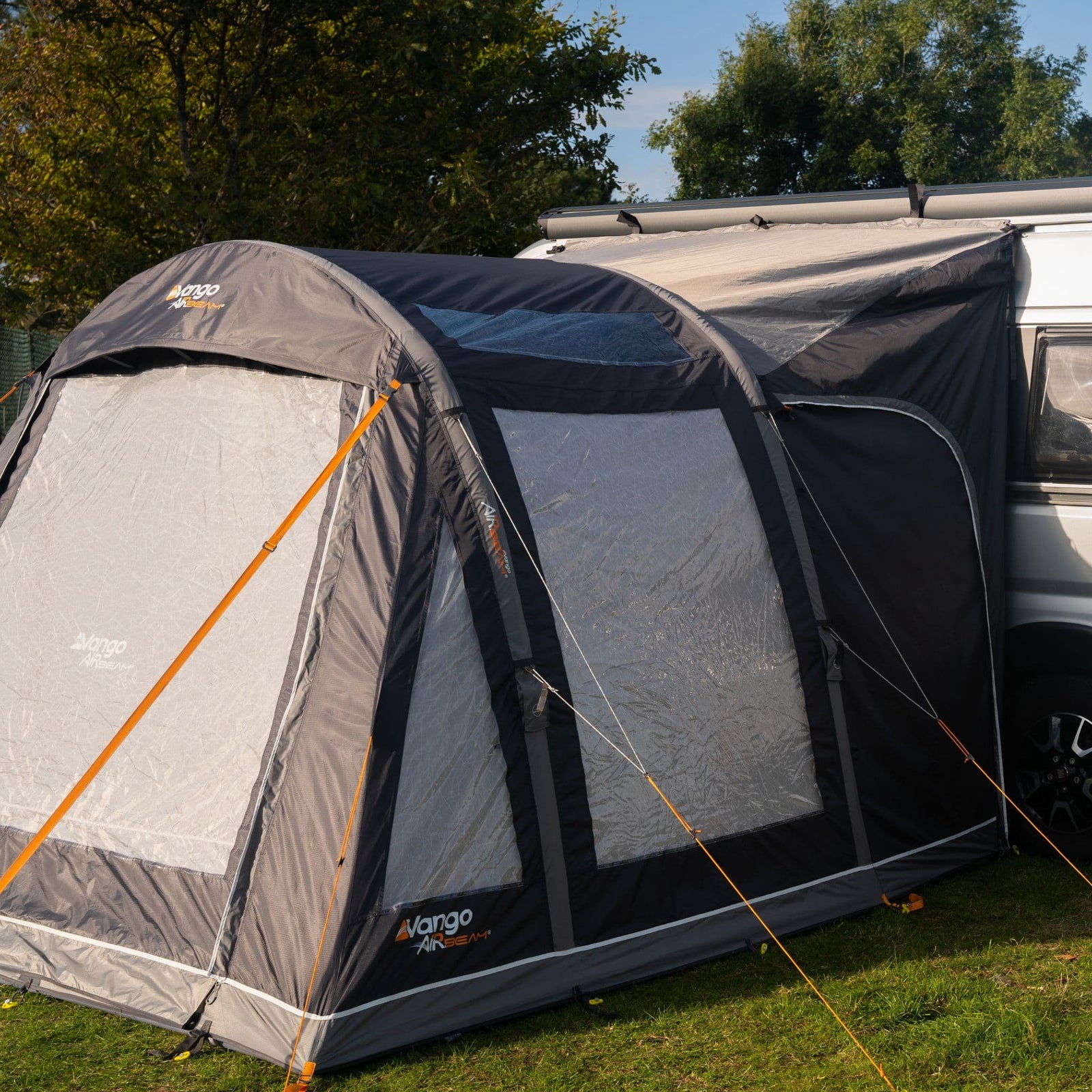 Side view of the Vango Kela Pro Air Mid Drive Away Awning connected to a campervan, illustrating the spacious interior and robust mid-height inflatable framework.