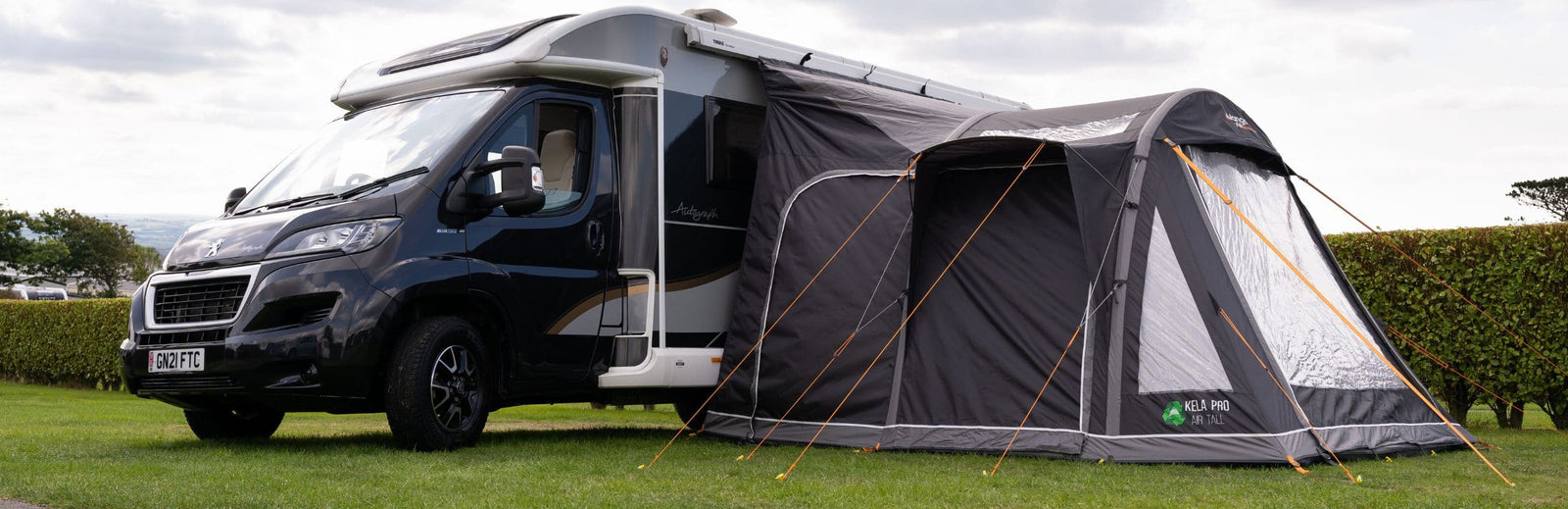 Vango Kela Pro Air Tall Drive Away Awning set up attached to a motorhome, offering extra living space with its durable 6000HH waterproof material and innovative Pre-angled Beam design.