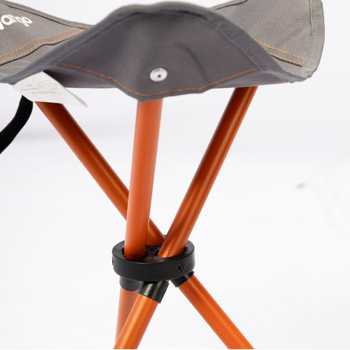 Close-up of the Vango Micro Stool Excalibur’s sturdy orange steel frame and tripod design, highlighting its strong and compact construction.