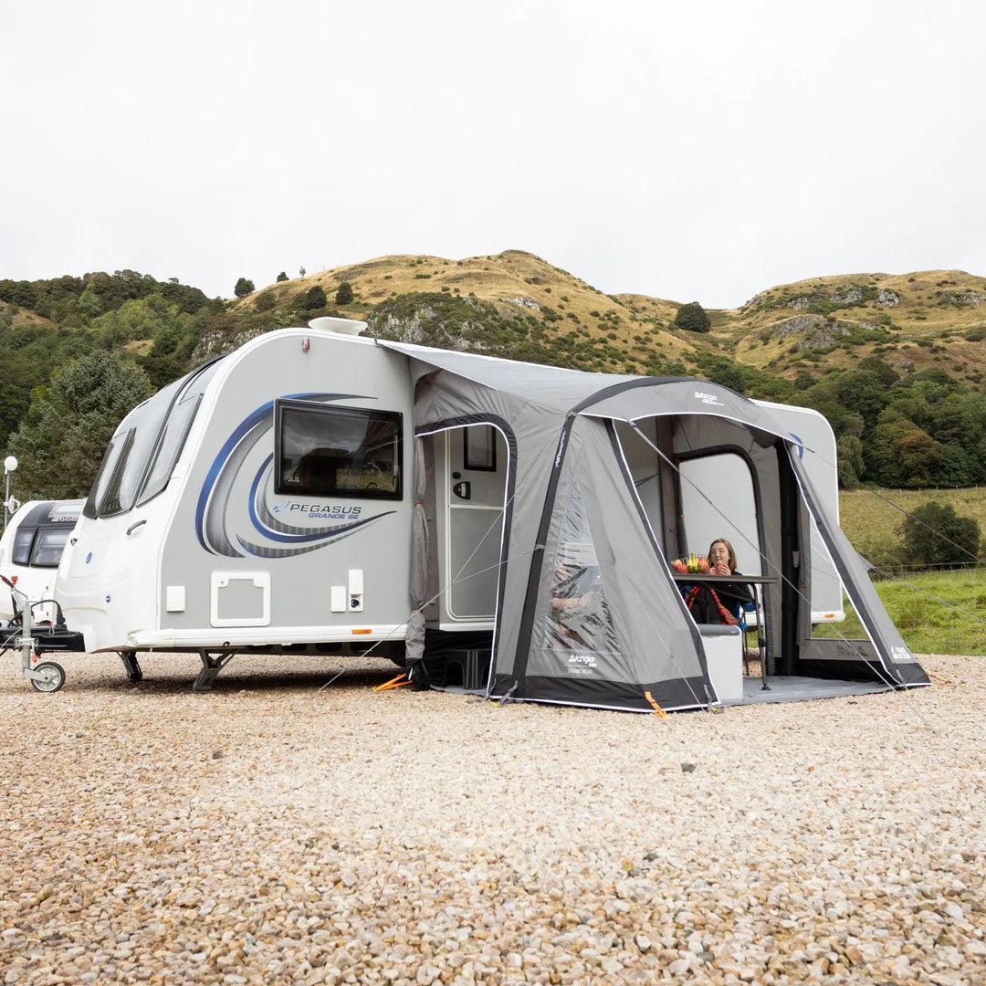 Lifestyle photo of a Vango Palma Air 260 Caravan Awning with front door open attached to a caravan on a hard-standing pitch.