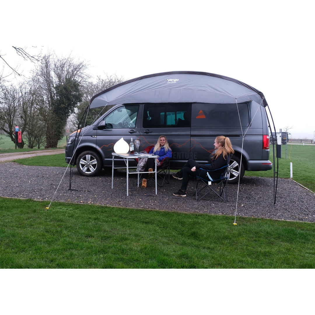 Vango Poled Sun Canopy 3M attached to a campervan, offering shaded outdoor space for relaxation.