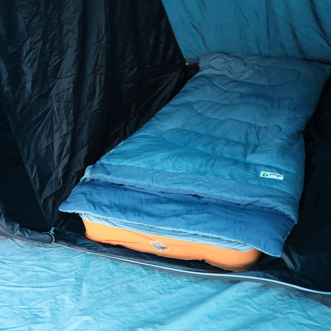 Side view of the Vango Shangri-La II 15cm Grande self-inflating mat inside a tent, featuring the Cyclone valve and supportive foam design for camping use.