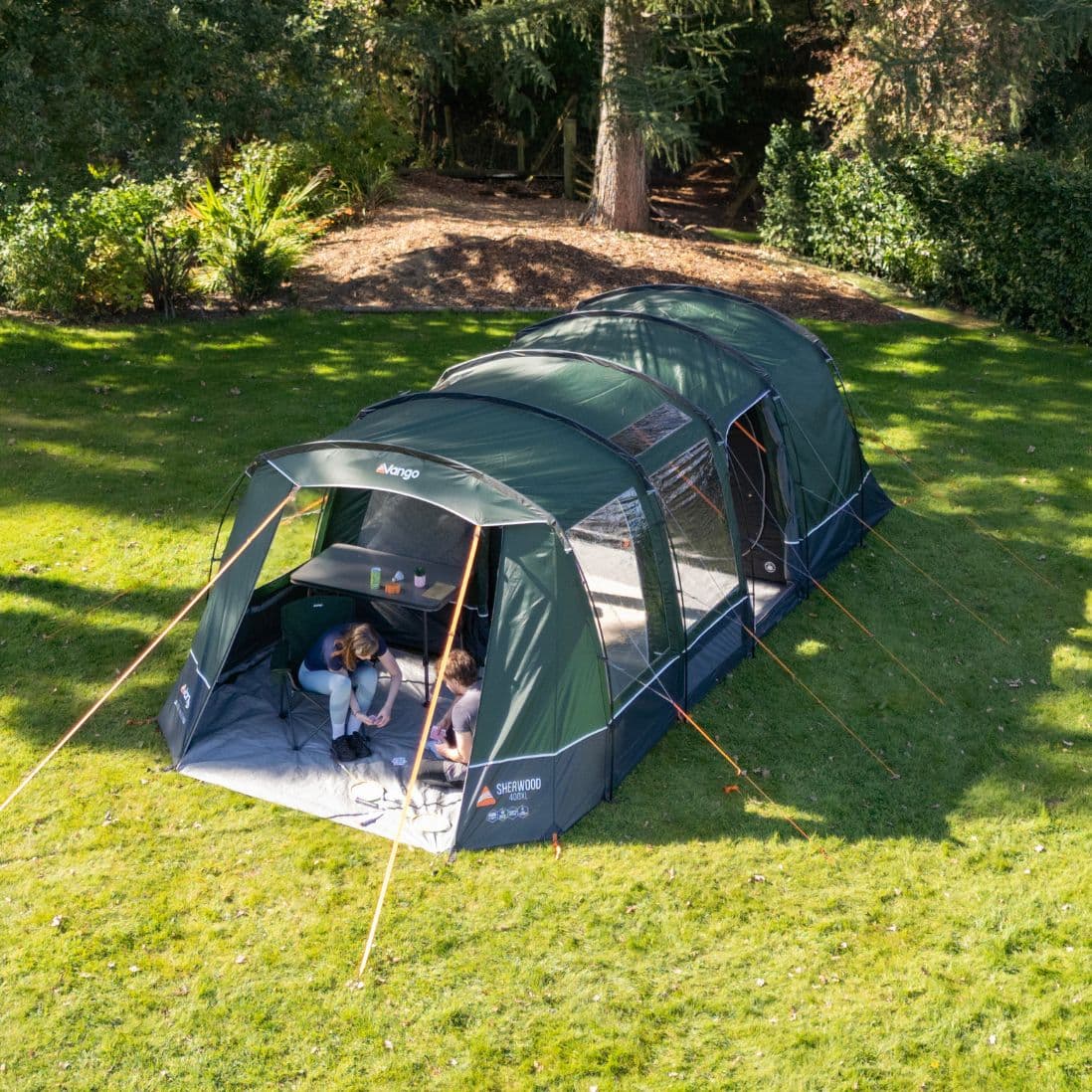 Lifestyle view of the Vango Sherwood 400XL Poled Tent, showing its pre-attached awning and outdoor seating area.