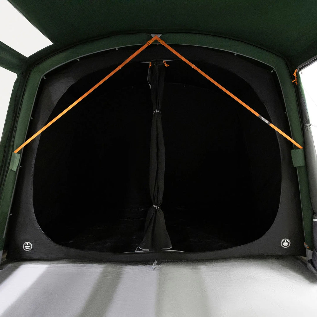 A close-up view of a Vango Sherwood Air TC 400 Tent bedroom, showing a black interior curtain with Vango TBS (Tension Band System) orange support straps against a dark green outer fabric.