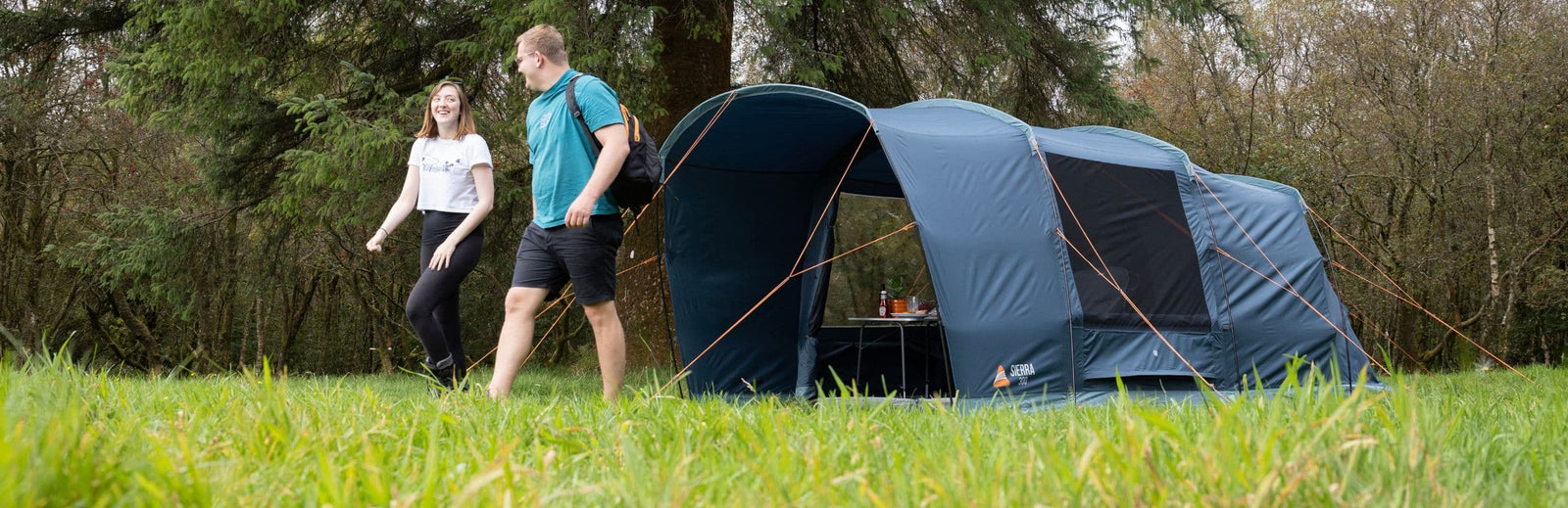 Lifestyle image of the Vango Sierra 300 Poled Tent pitched in a woodland setting, highlighting the spacious living area and covered entrance, perfect for a 3 man tent for weekend camping