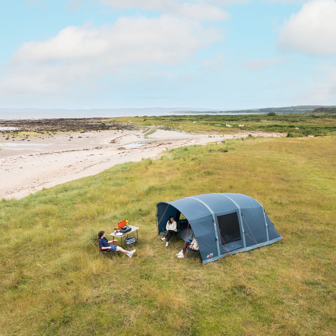 Vango Sierra Air 500 Tent on Grass: A scenic view of the Vango Sierra Air 500 5-man tent pitched on grassy terrain near a beach, showcasing its robust design and spacious structure.