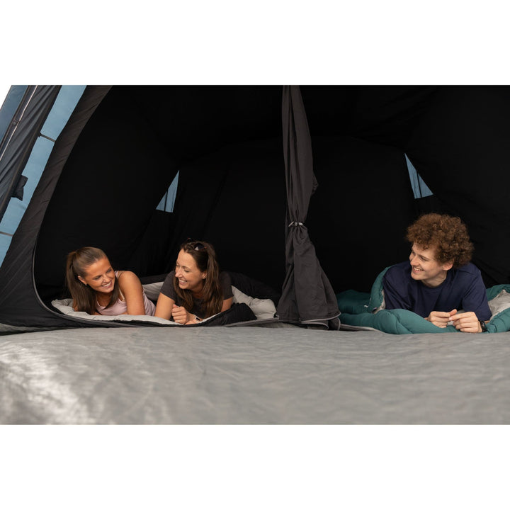 Interior View of Vango Sierra Air 500 Tent Bedroom: Close-up of three people inside the Vango Sierra Air 500 5-man tent's bedroom, highlighting its midnight bedrooms and spacious sleeping area.