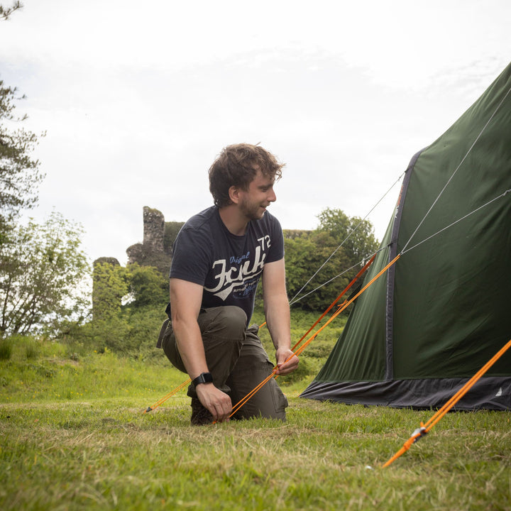 A person pegging out the Vango Sierra Air TC 300 AirBeam Tent