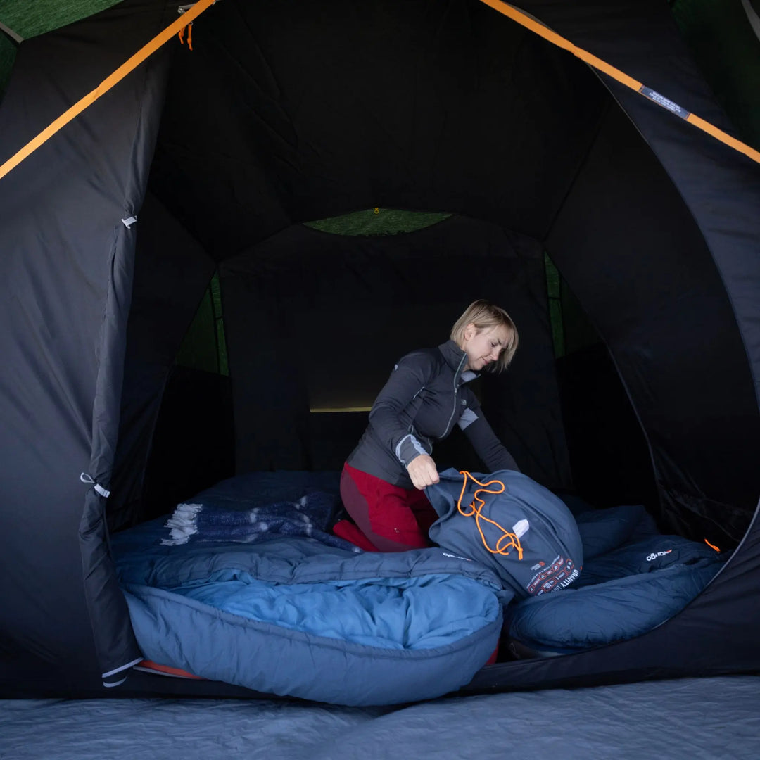 Person inside a Vango Sierra TC 300 Poled Tent with camping gear, including a sleeping bag and backpack.