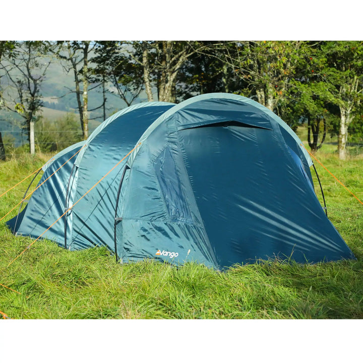 Front view of Vango Skye 300 tent pitched in a grassy area, showing closed back panel and orange guy lines in place.