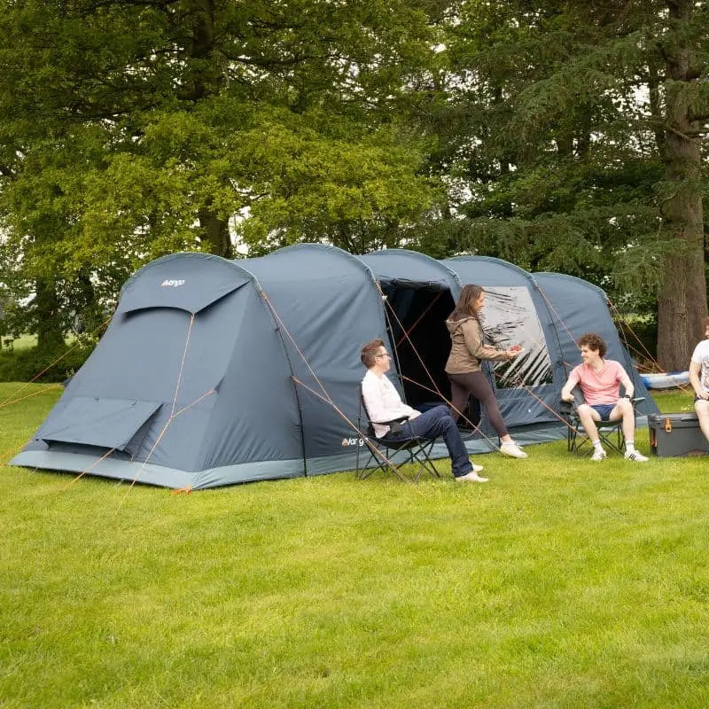 Vango Tacoma 800xl is pitched on a grassy lawn with several people sitting and standing around it, with trees in the background.
