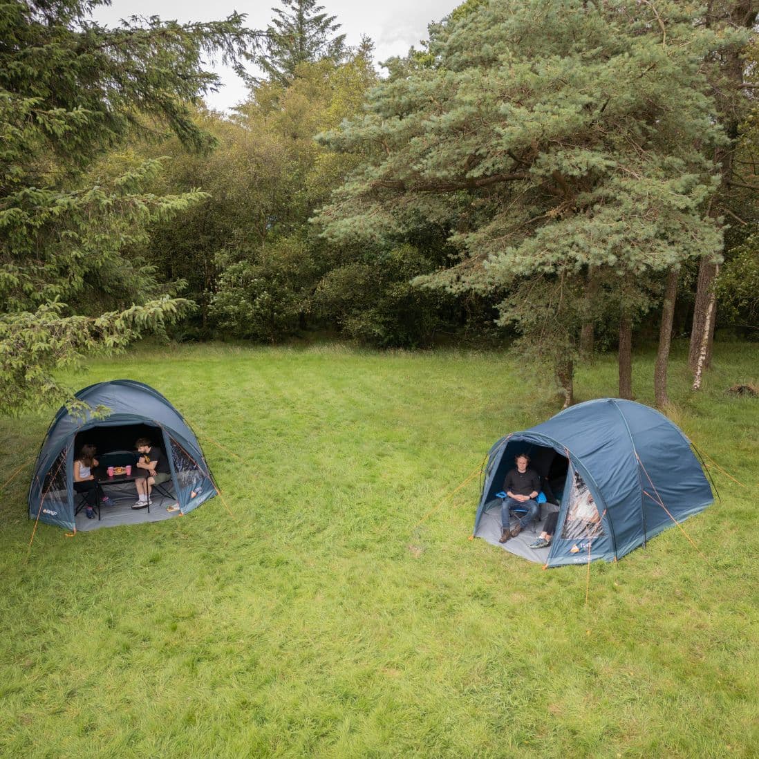 Two Vango Tahoe 400 4 man tents set up in a scenic outdoor area, each accommodating a small group.