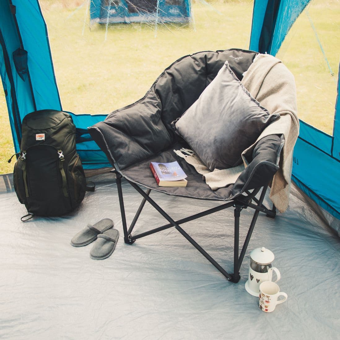 Lifestyle setup of the Vango Titan 2 Chair in a camping environment, showing its premium cushioning and 180kg load support.