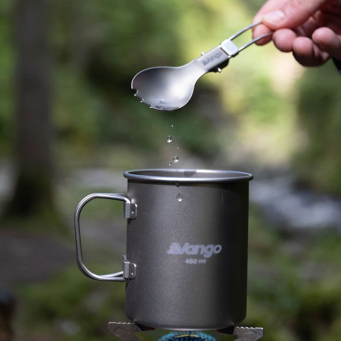 Vango Titanium Folding Spork in use with a Vango camping mug. Lightweight camping utensil for outdoor cooking and dining.