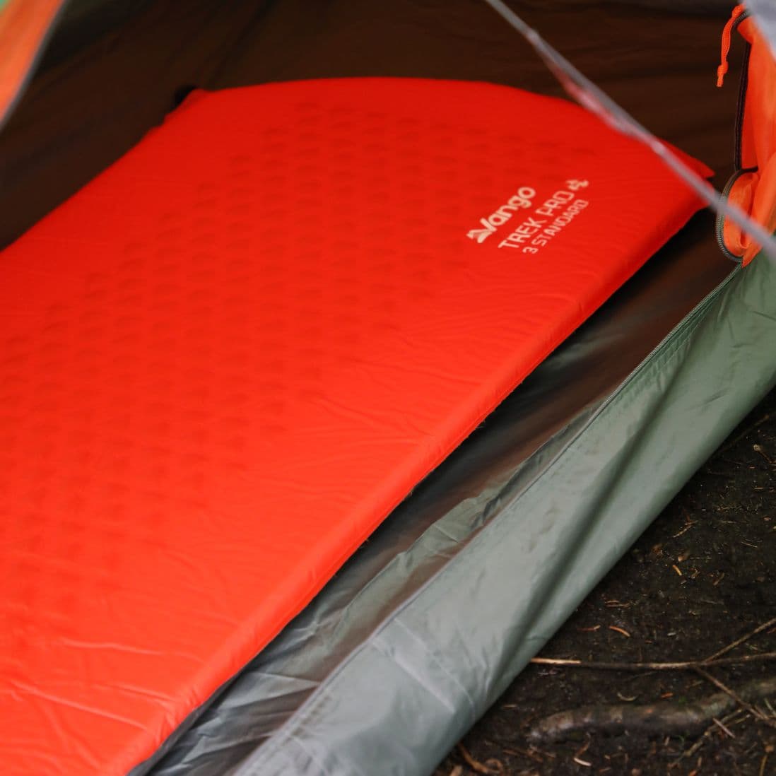 The Vango Trek Pro 3 Standard mat in use on a forest trail, emphasizing its portability for trekking.