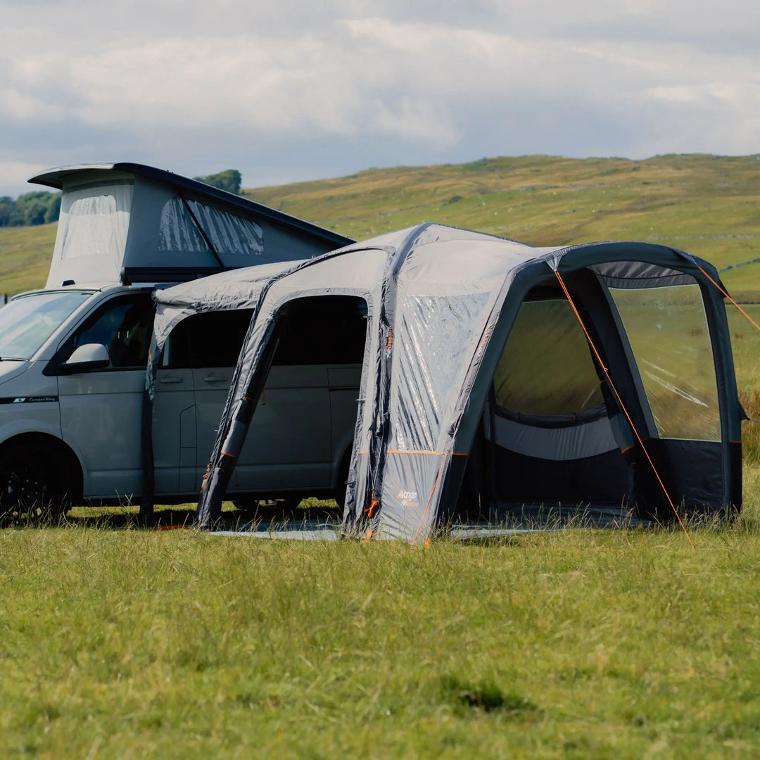 Vango Versos Air Low campervan awning set up next to a VW campervan with a pop-up roof, offering additional living space.