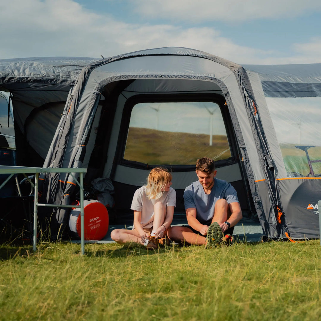 A couple enjoys the spacious interior of the VW campervan awning, supported by pre-angled beams for enhanced stability and headroom.