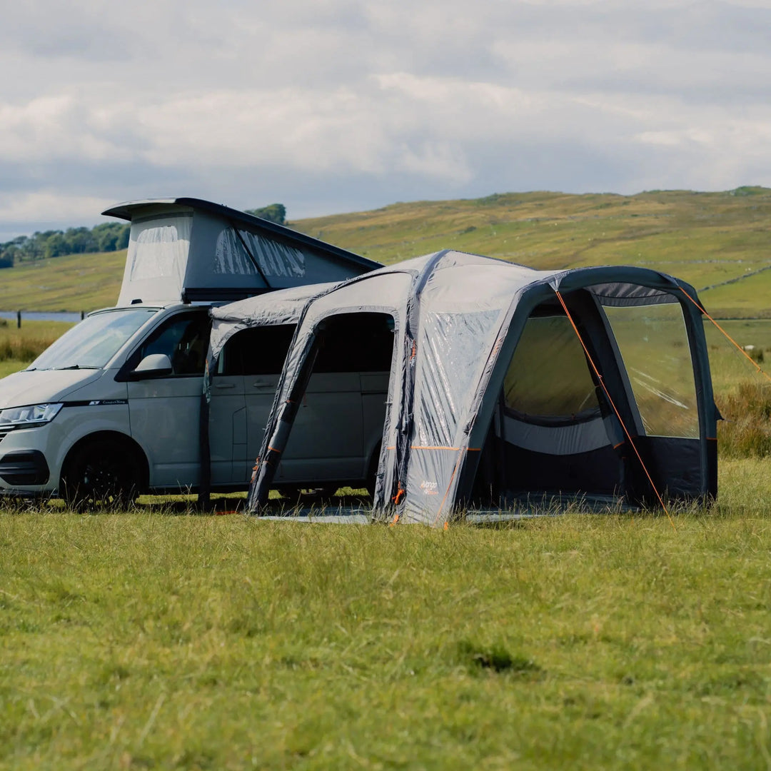 Scenic field setup of the Vango Versos Air Low drive-away awning, attached to a VW campervan, blending convenience and outdoor adventure.