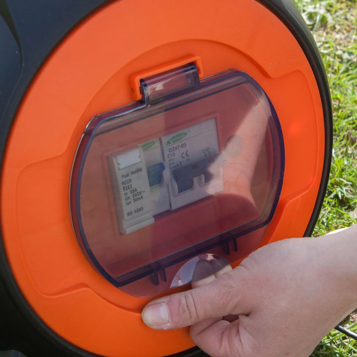 Hand opening the RCD safety switch cover on the Vango Voltaic Roll Away Mains Unit.